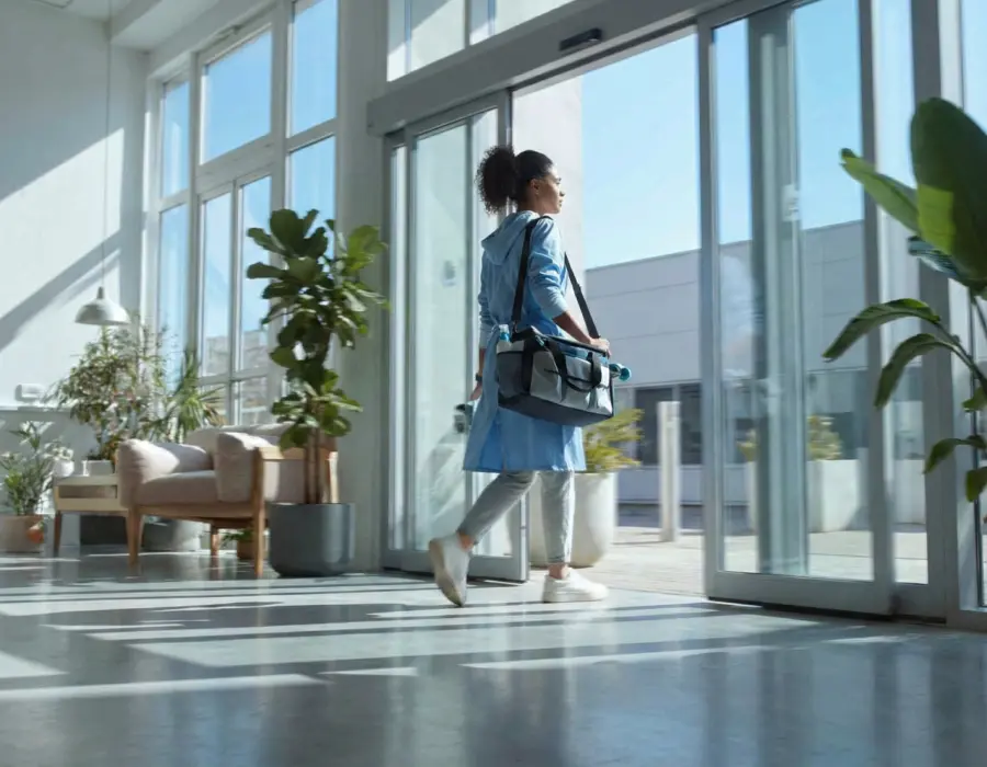 Agent de propreté Clindit arrivant dans des bureaux modernes avec son équipement pour assurer l'entretien des locaux en remplacement d'un agent absent.