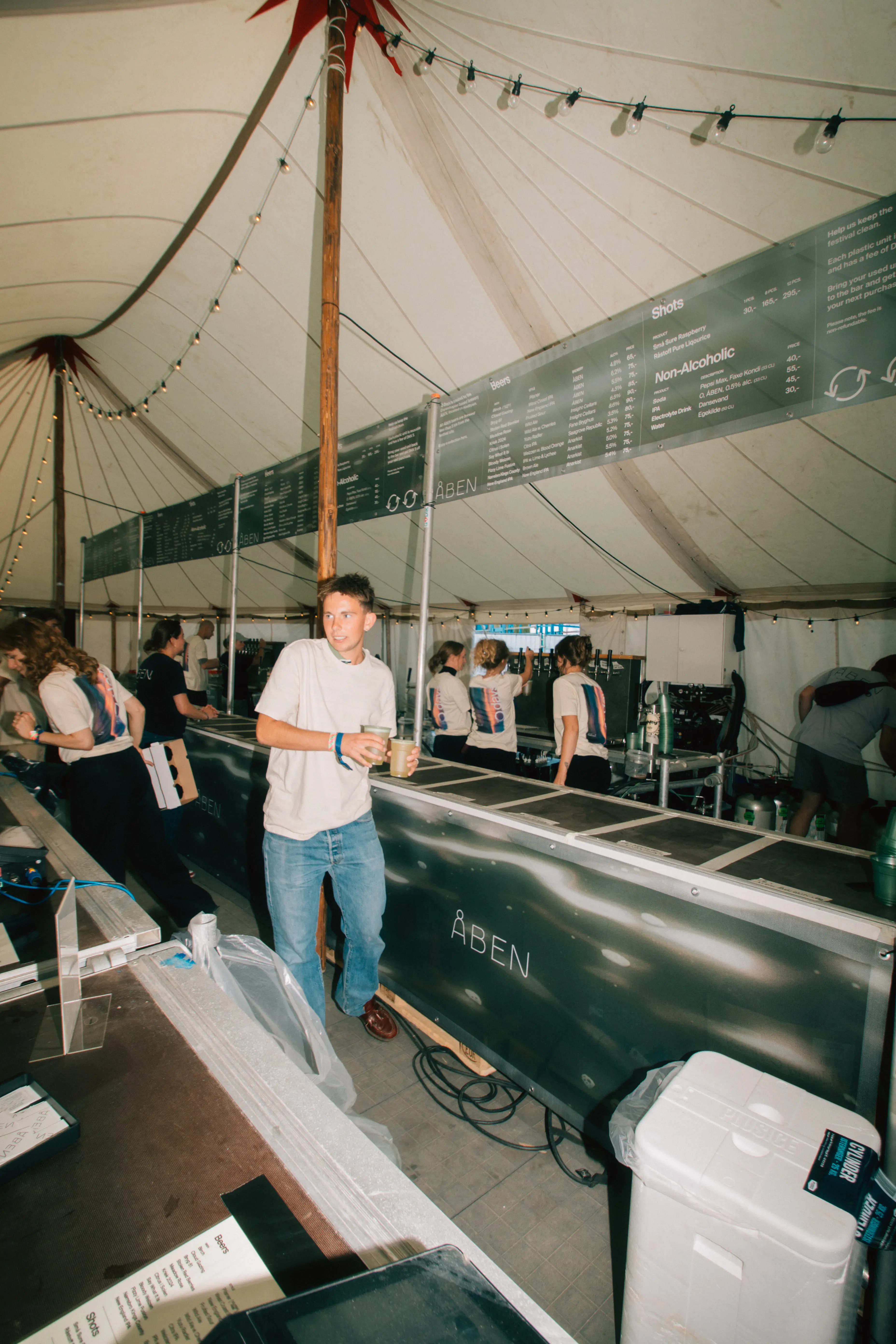 O Days volunteer in the bar delivering beverages to a festival goer.