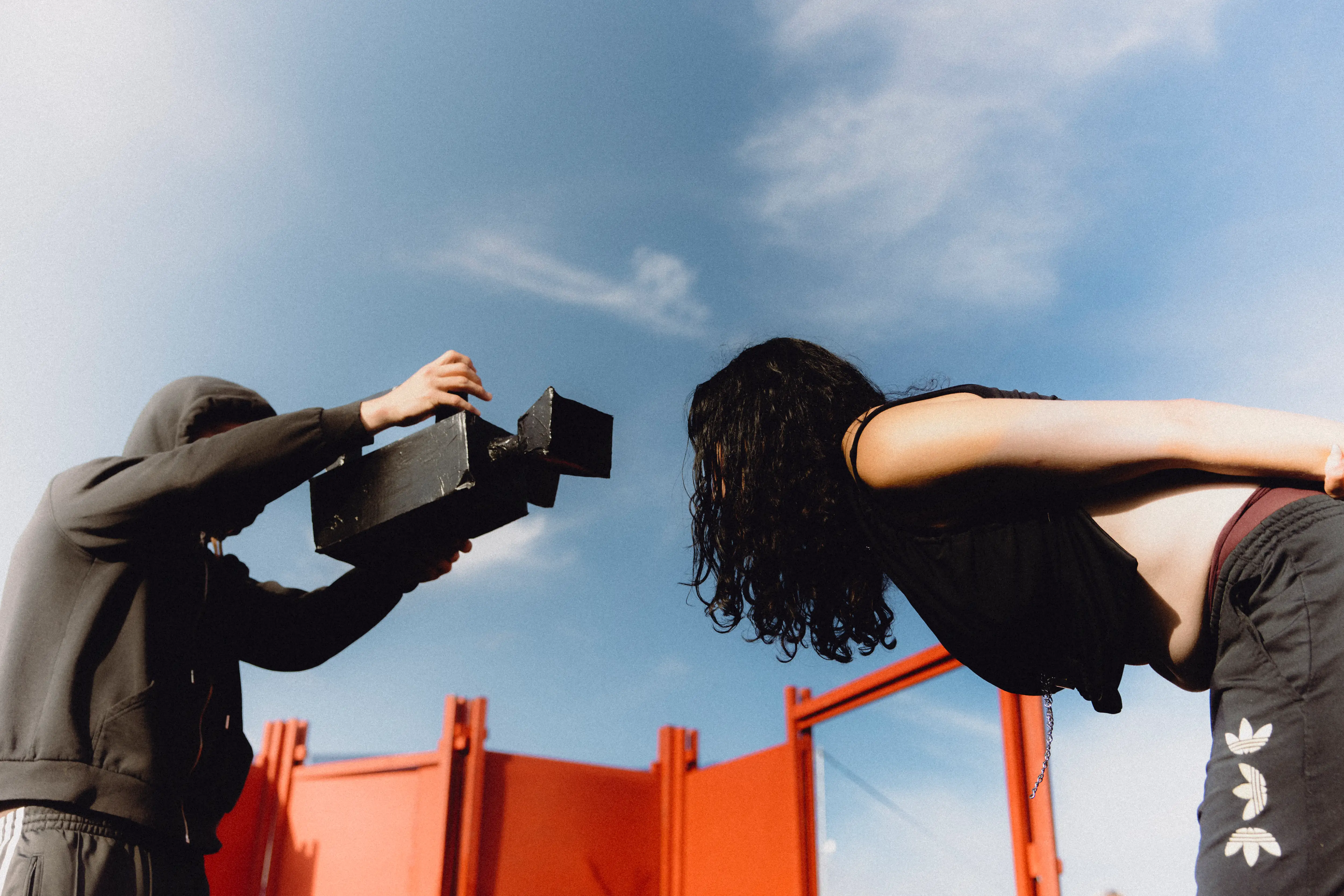 The group "Unearth2 performing "Shoot". One of the performers points a prop camera at the other performer.