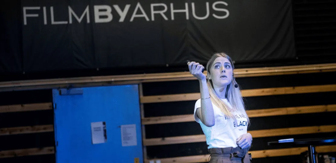 A woman standing on a stage holding a microphone.