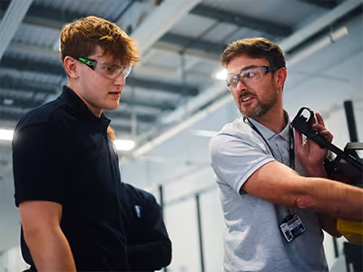 Senior colleague showing a junior team member how to do something