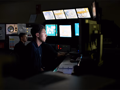 Male service professional watching a room full of screens
