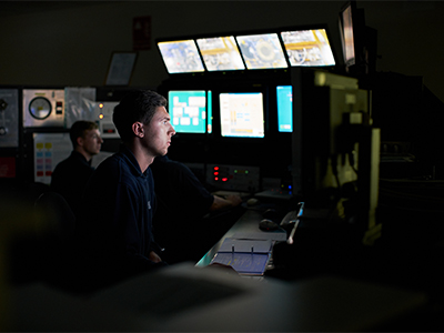 Male service professional watching a room full of screens