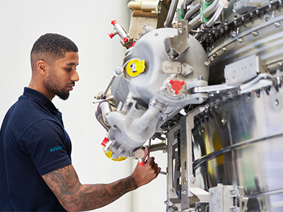 Male engineer working on an engine in a bright workshop