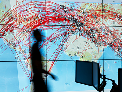 Blurred image of person walking past a map of the world