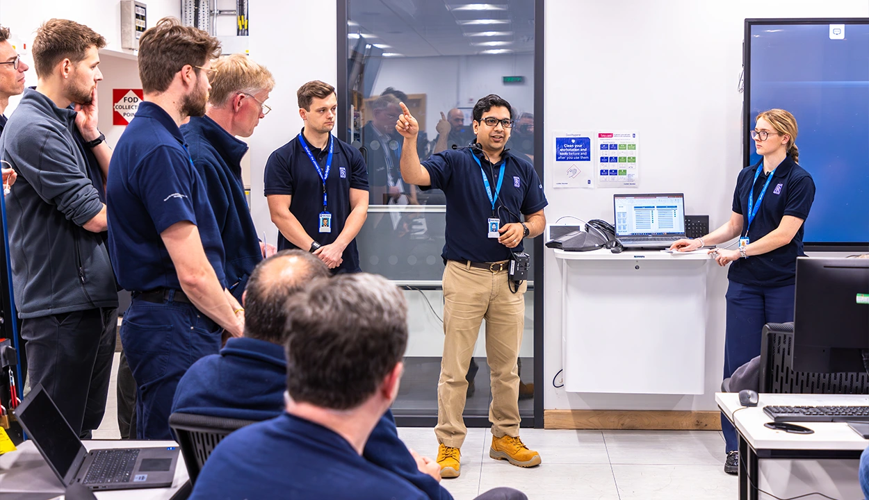 A lead engineer chatting to his team of engineers at a meeting