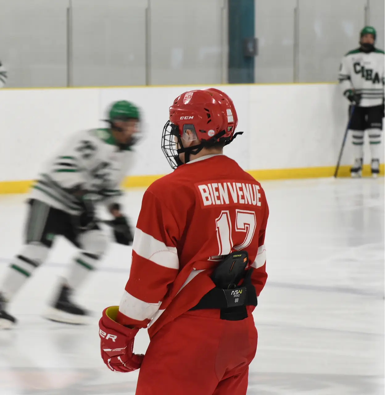 A hockey player in red uniform with number 17 stands on the ice during a game.