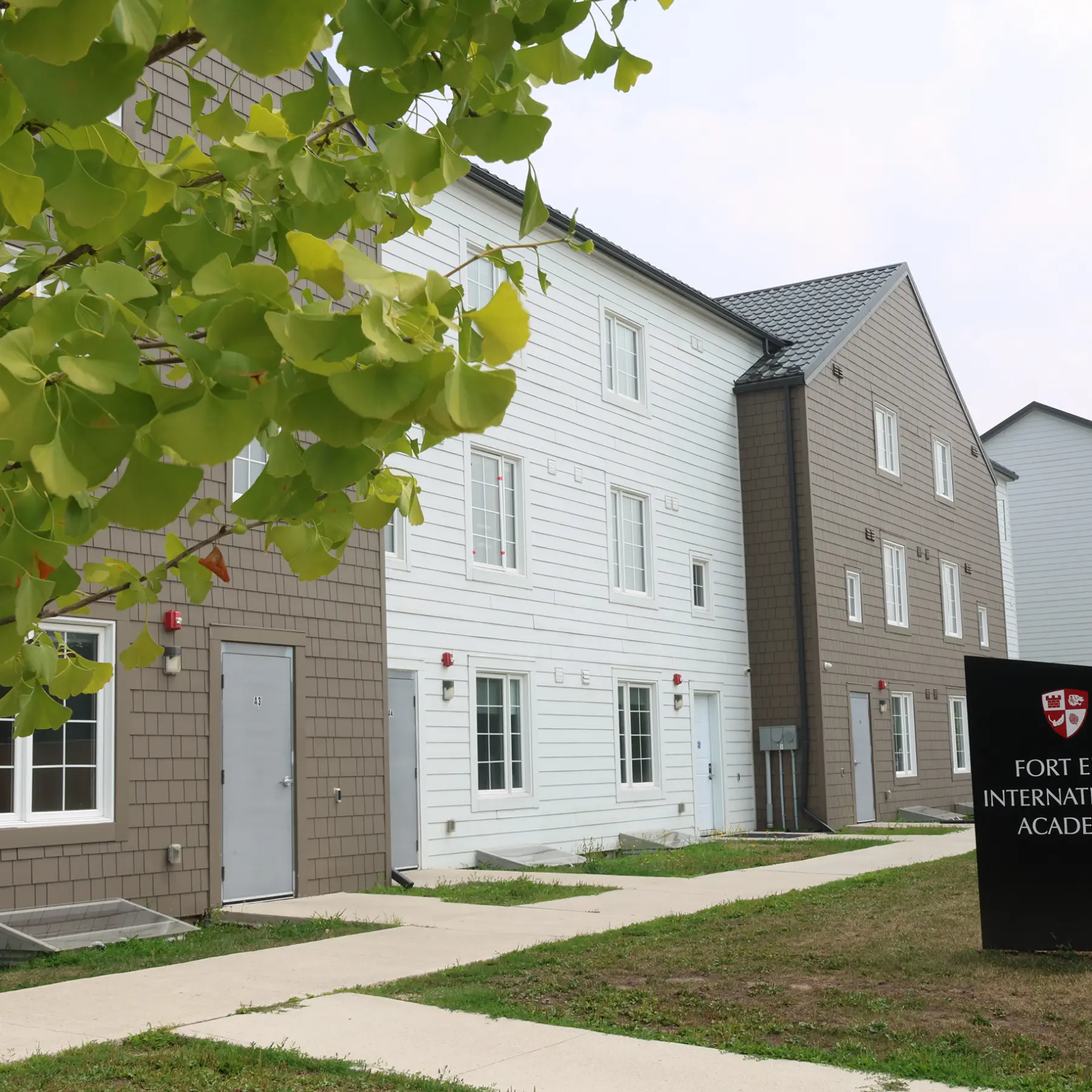 A row of townhouse-style buildings with a sign for Fort Erie International Academy.