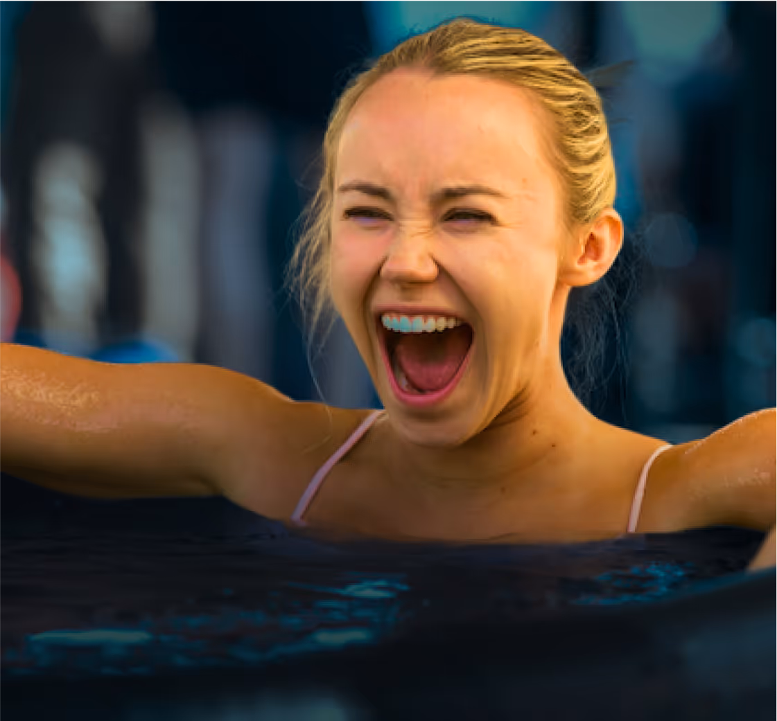 Smiling woman about to enter a cold plunge pool during a guided cold plunge session