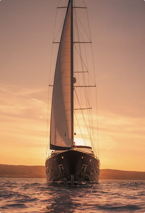 Sailboat with a raised sail on calm water at sunset, with hills in the background.