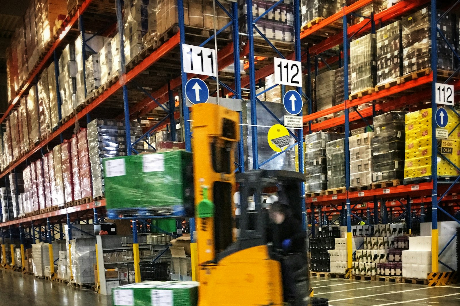 Carretilla elevadora en un almacén con estanterías de palés