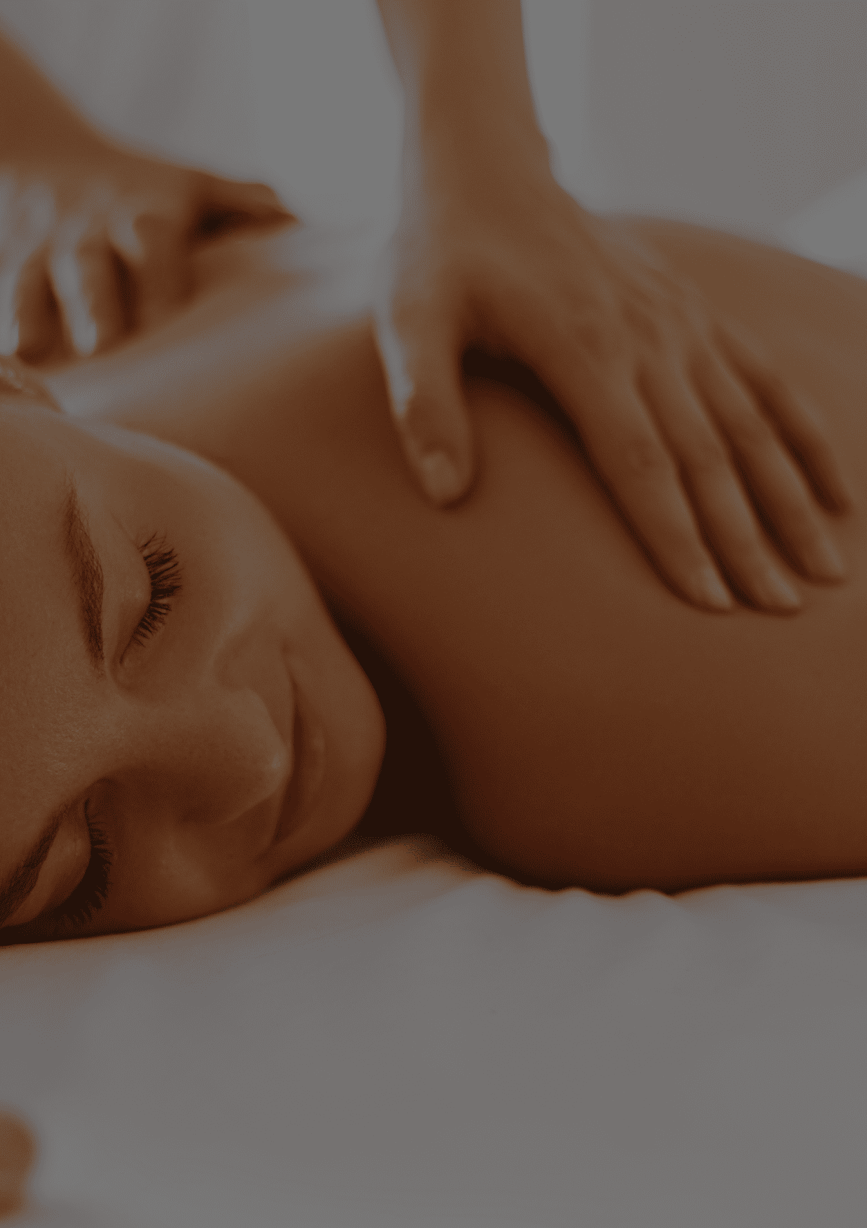 Person receiving a relaxing back massage with eyes closed on a white surface.