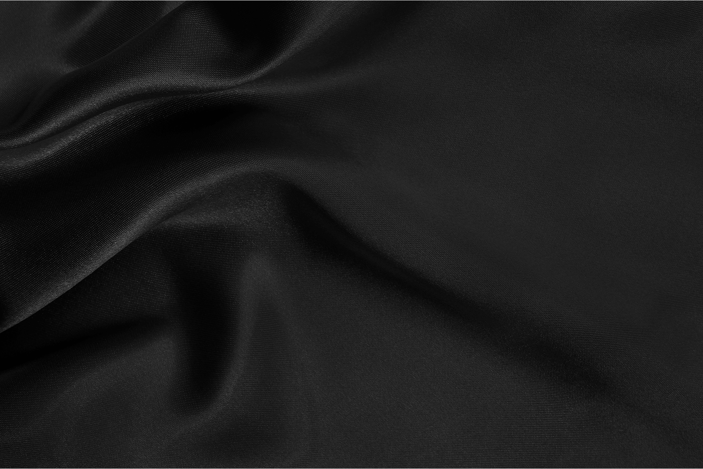 Close-up of smooth black fabric with gentle folds and a subtle sheen.