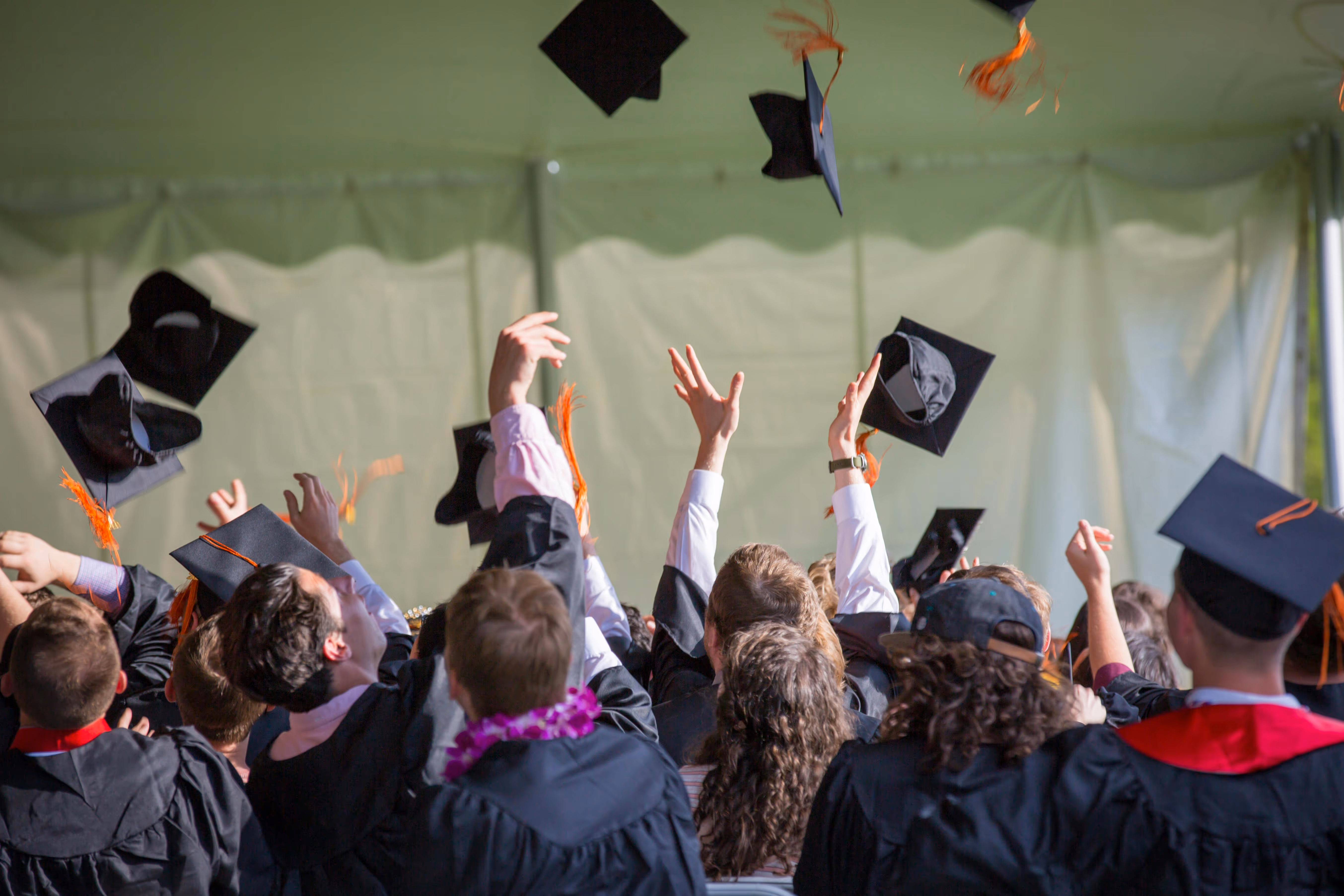 image of students tossing their caps into the air