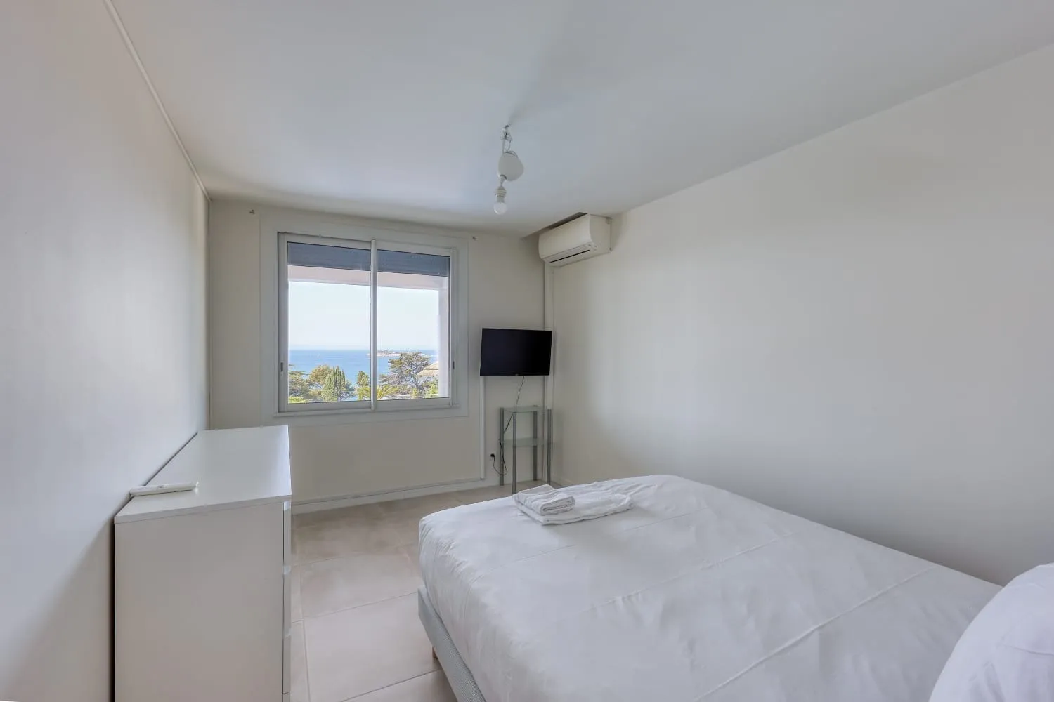 L'une des chambres de la villa. Grande chambre équipée d'une télévision et avec vue sur la mer.