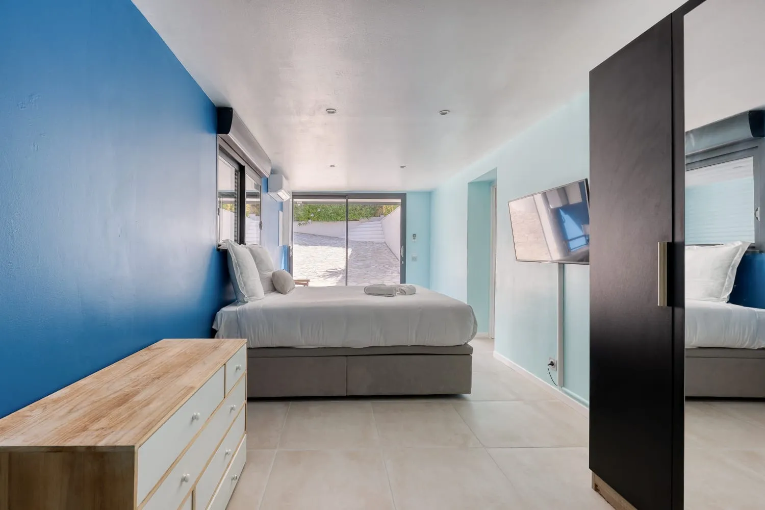 Suite parentale avec baie vitrée, placards et salle de bain privée.