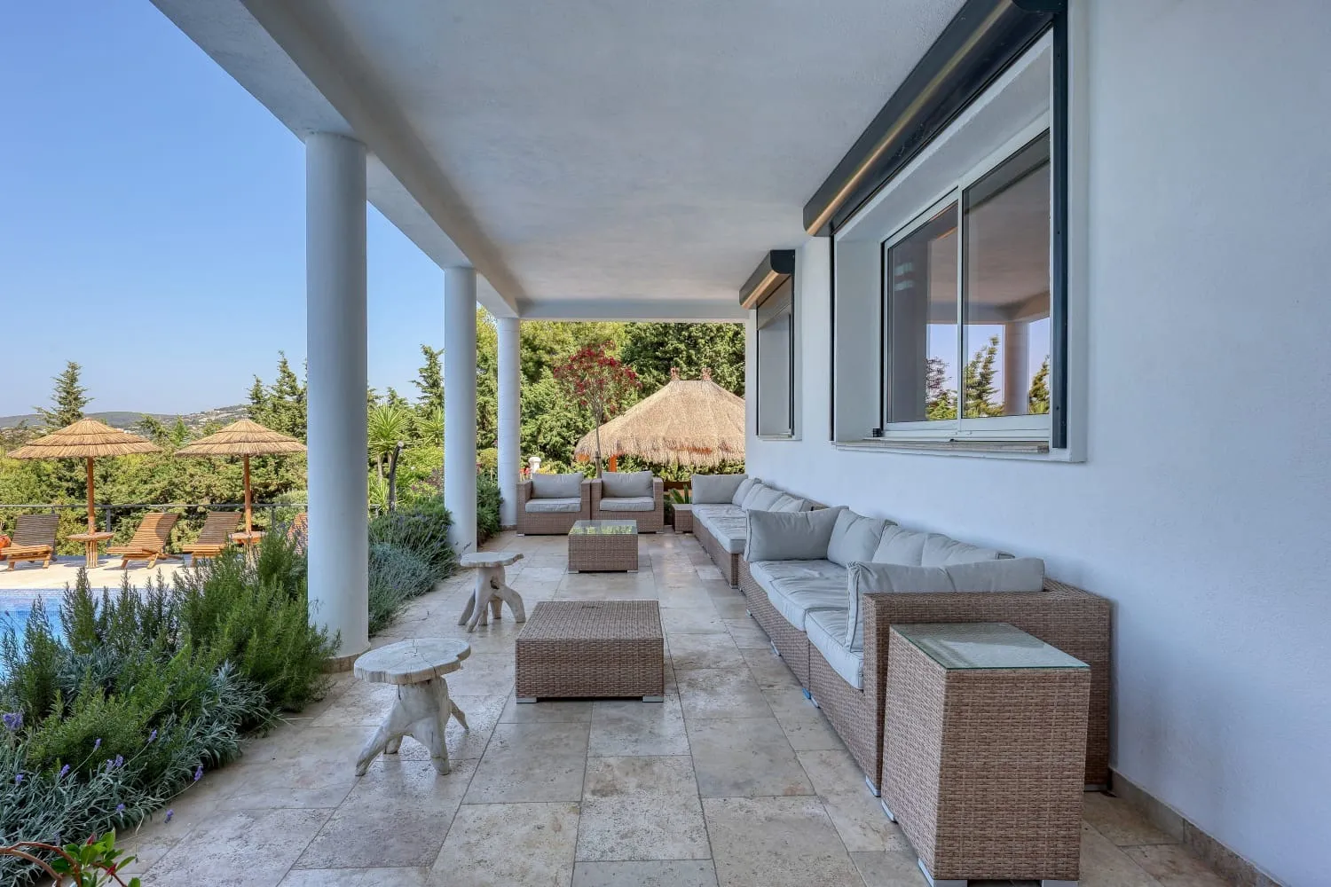 Terrasse extérieure avec table et canapés.