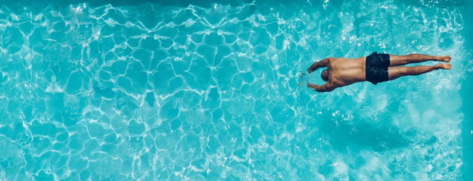 Image of a crystal clear pool professionally maintained and the owner's diving in