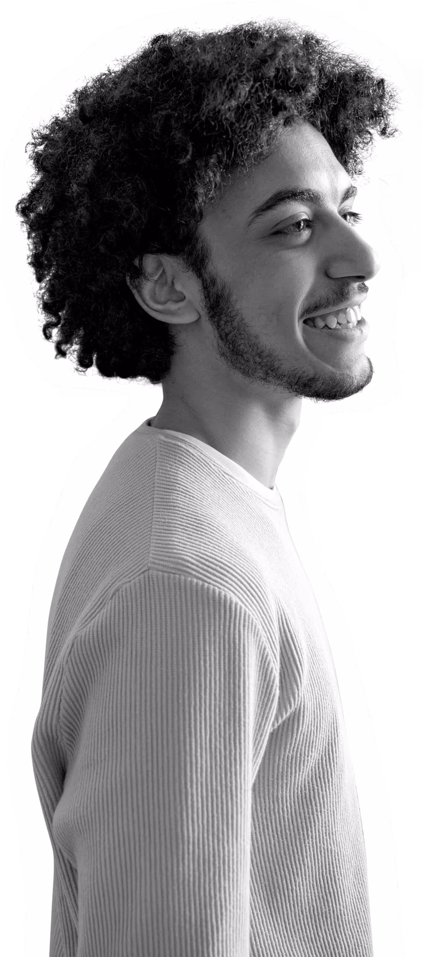 Young person with curly hair smiling in black and white profile shot