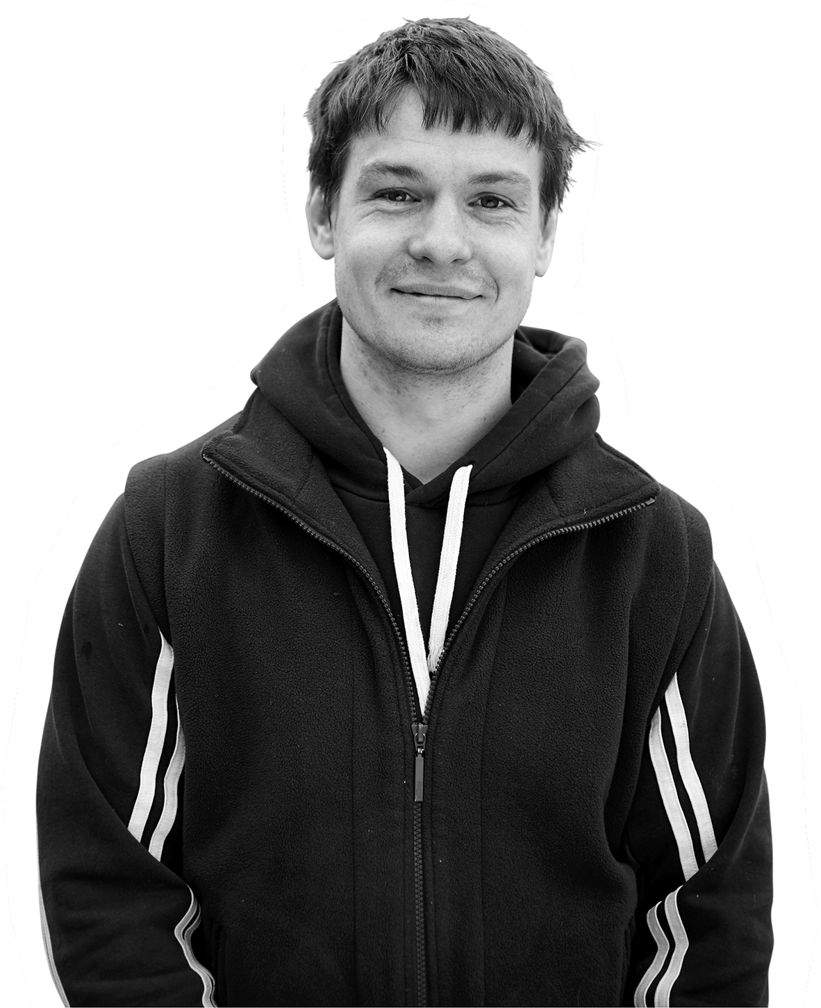 Person in black zip-up hoodie smiling softly in black and white