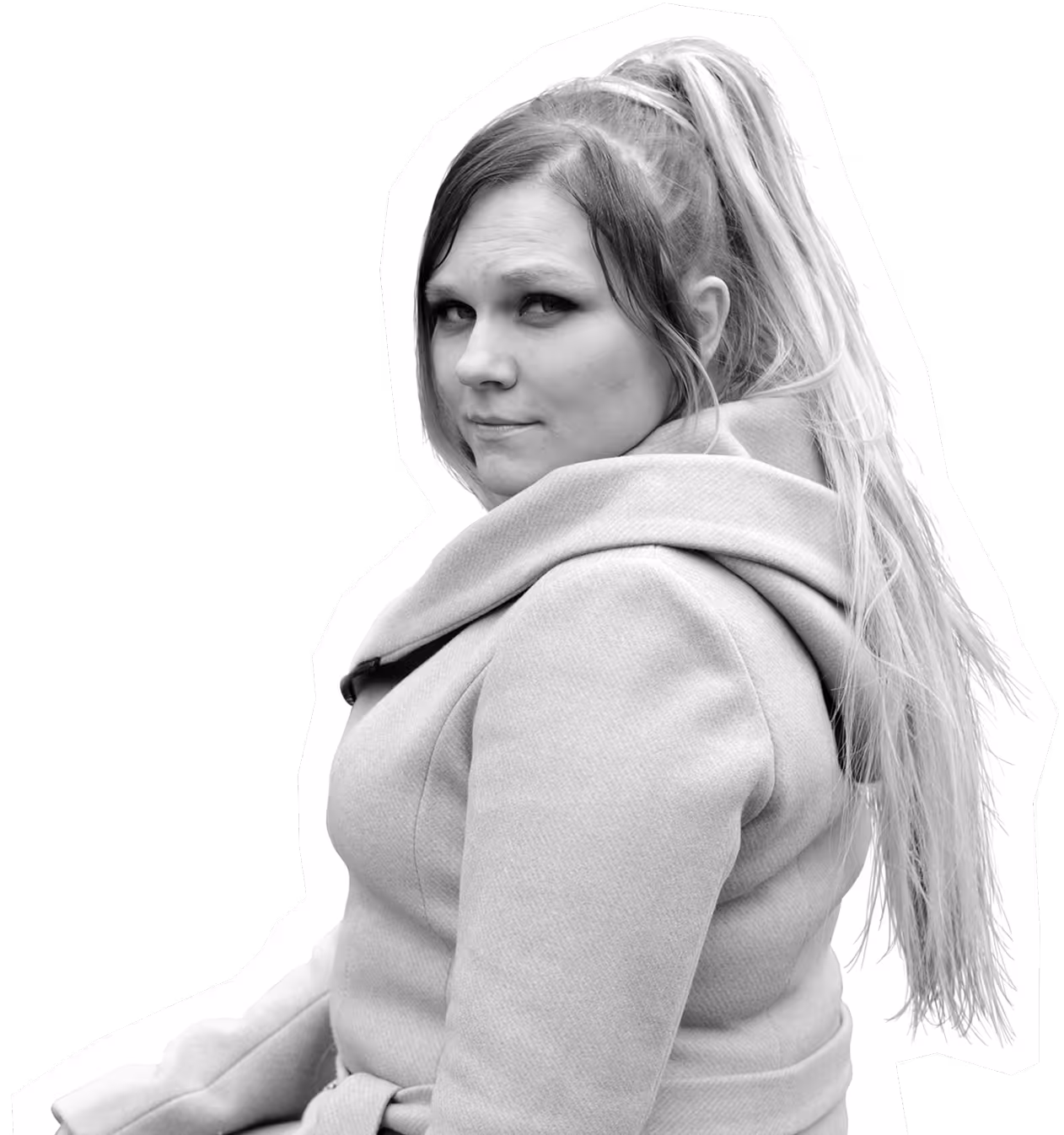 Woman in warm coat looking over shoulder with thoughtful expression