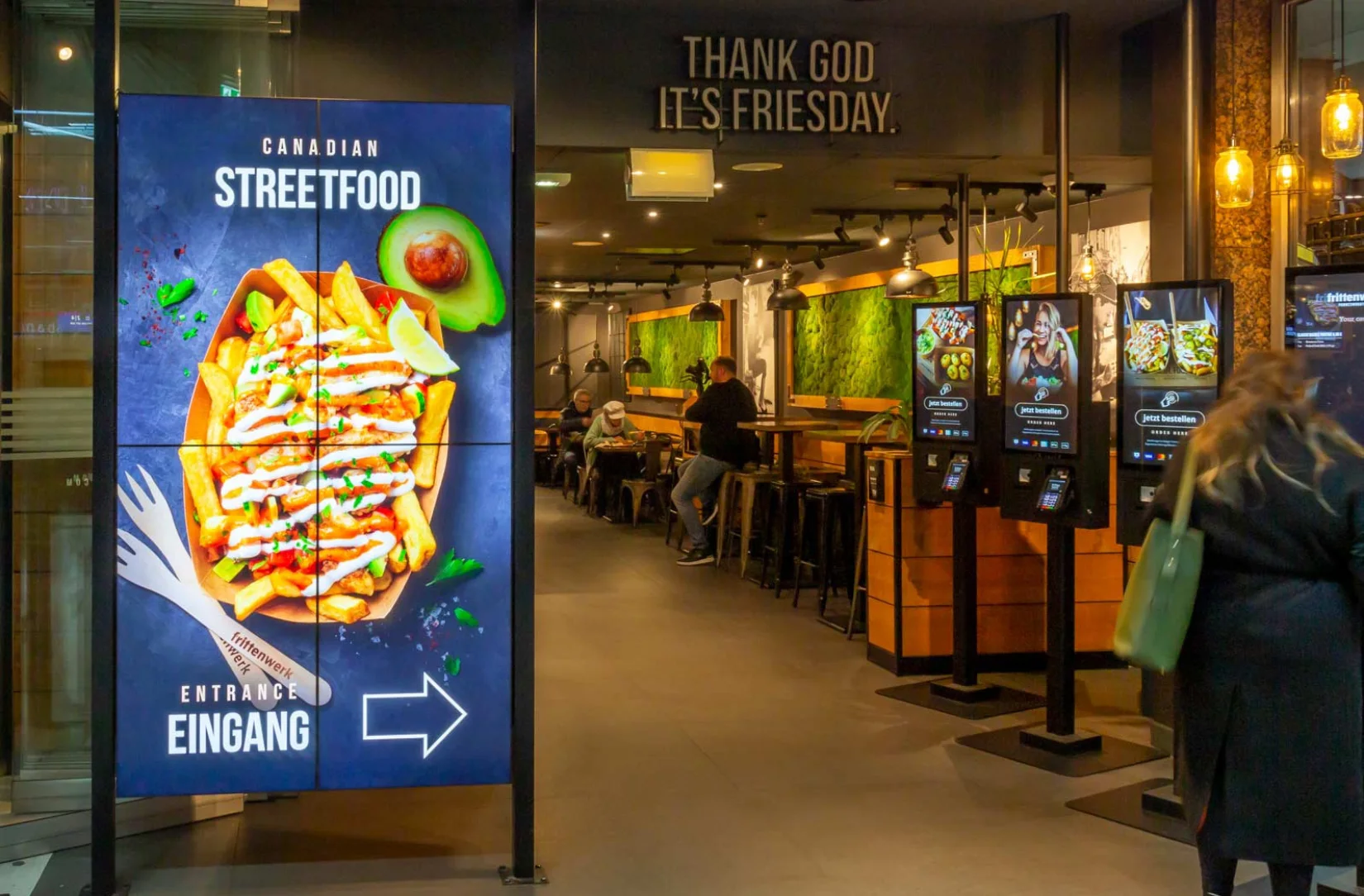 Digital Signage Display vor einem Laden von Frittenwerk