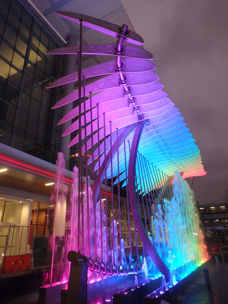 A colorful wing like sculpture with each tensile facade shaft acting like a feather.