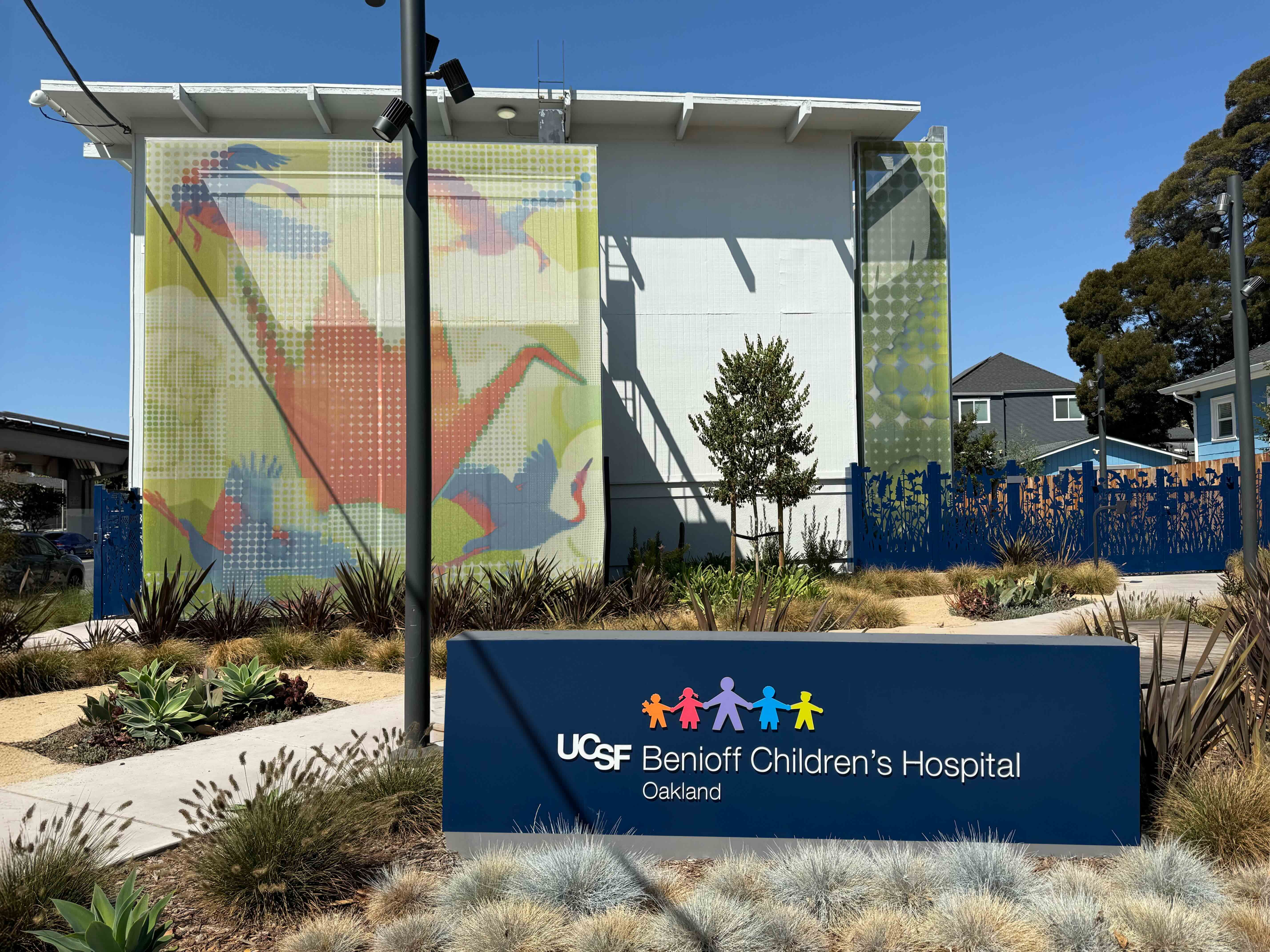 A pointellism graphic facade that features iconography of birds and an oragami swan.