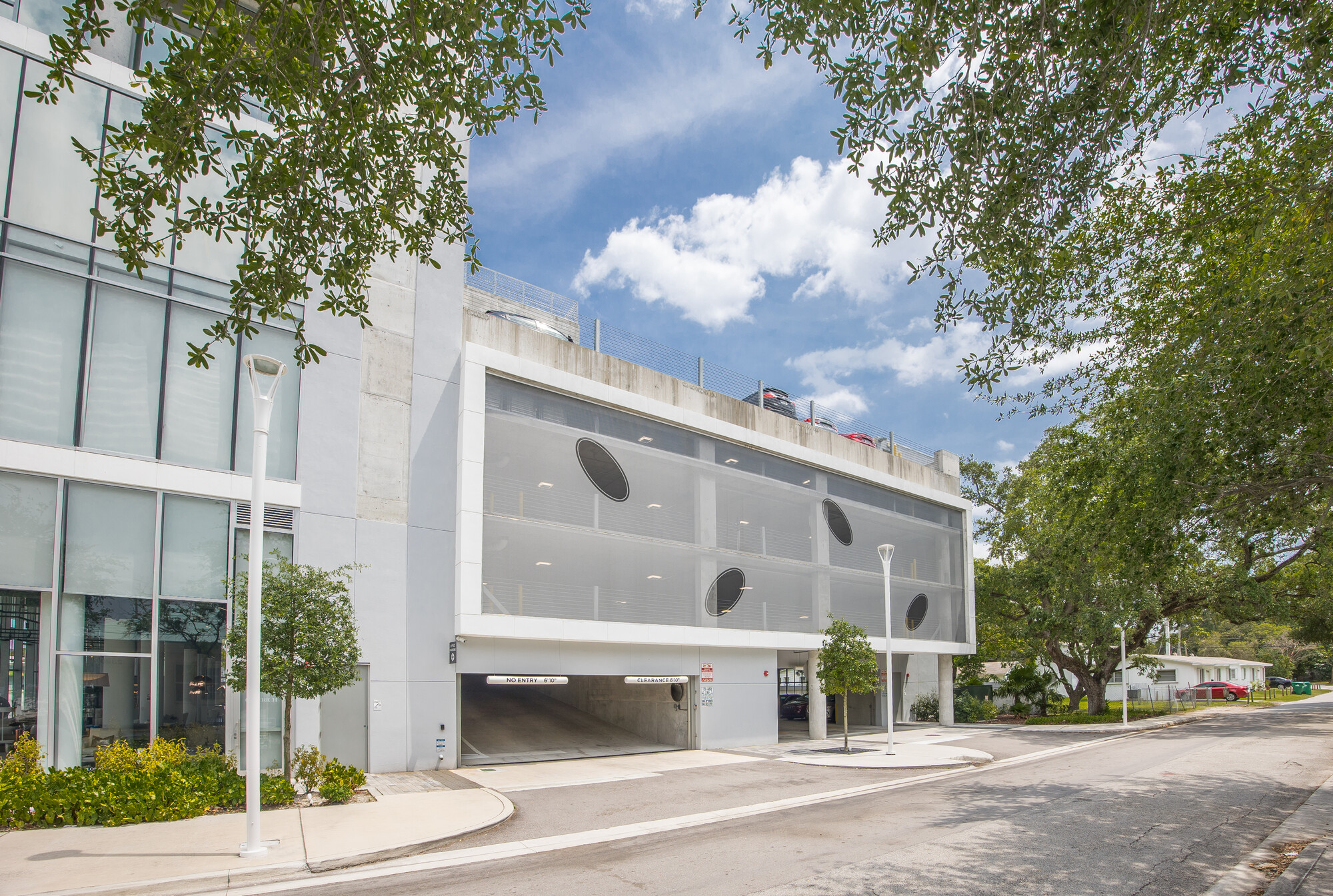 A white tensile facade with small black ovals scattered across it.