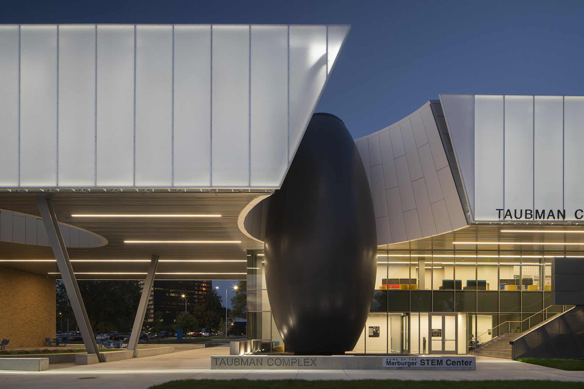 A futuristic facade lining the decorative entrance of a building. The facade material gives off a diffused glass look.