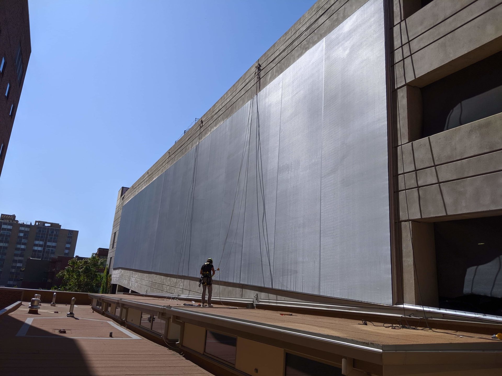 A plain black tensile facade sat on a parking structure.