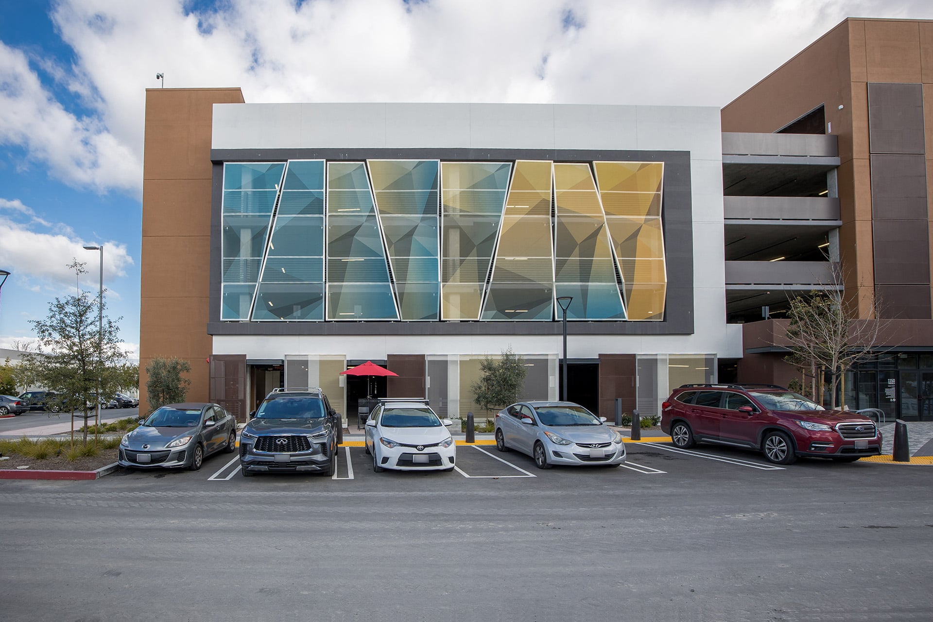A modular panel screen facade with a blue and yellow geometric triangular pattern.