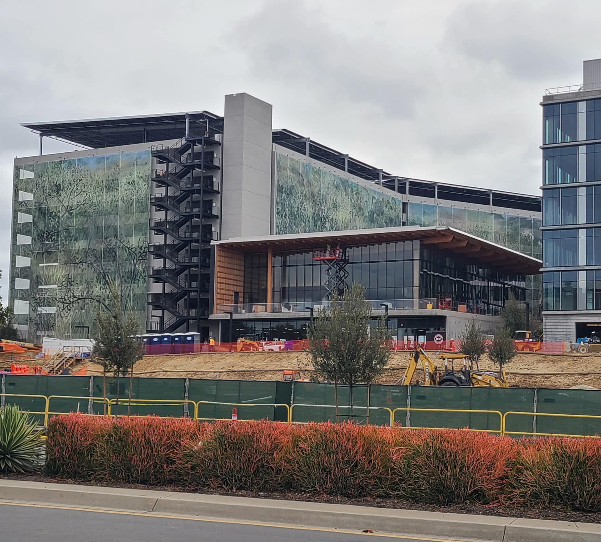 A wide shot of the building with a graphic green facade that features a forrest and tree theme.
