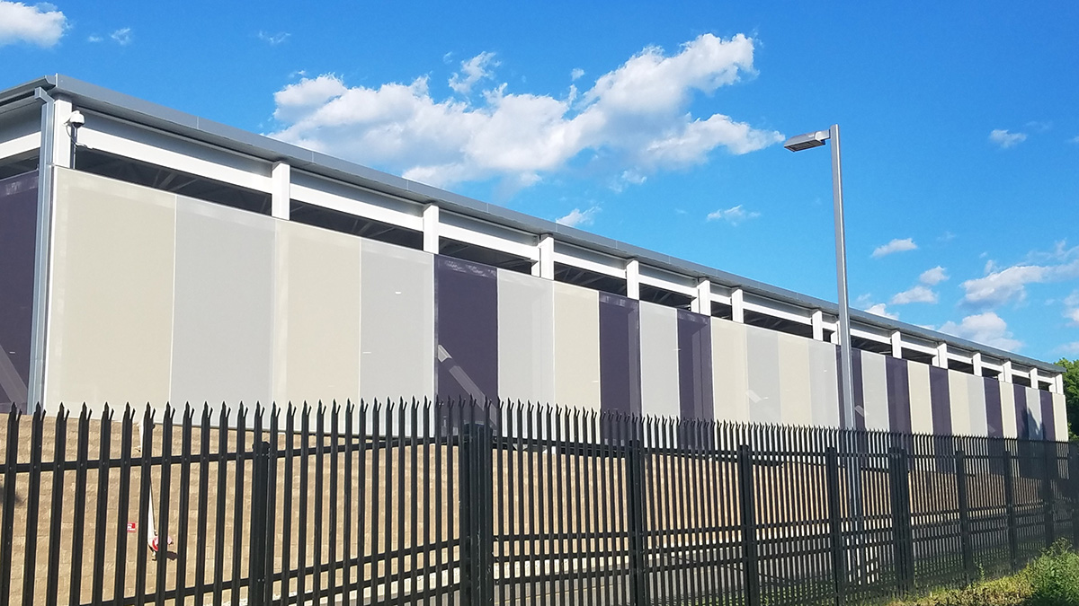 A multicolor monochrome 2D cladding screen mesh facade installed on a parking structure.