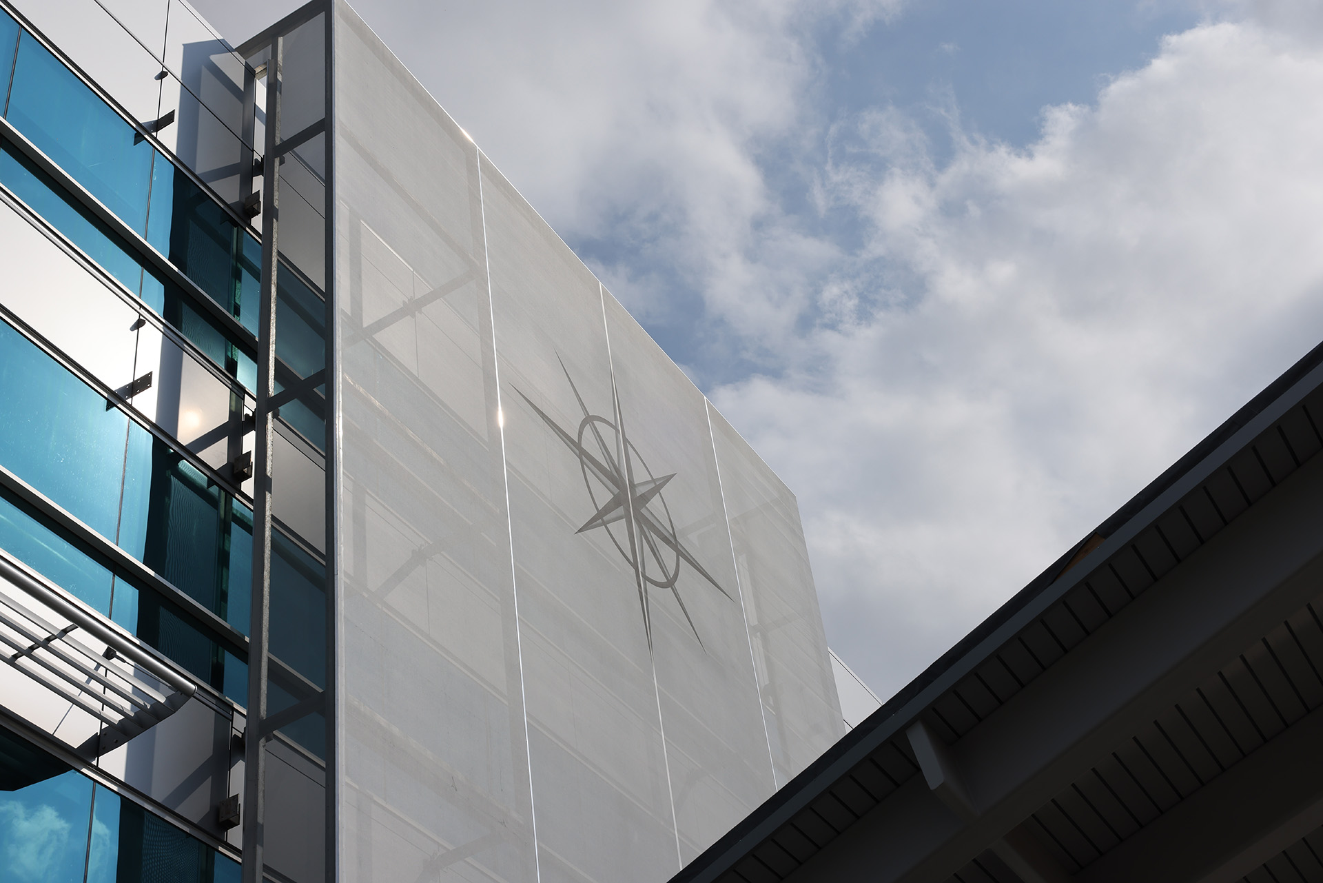 A simplistic white facade with a company logo printed onto the mesh.
