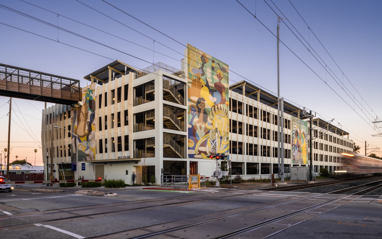 Three artistic facades sat on a parking structure depicting different scenes.