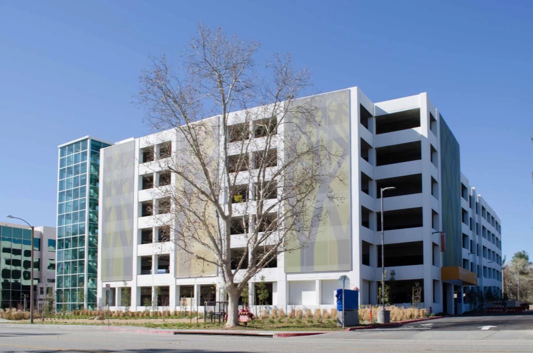 Three, five story facades that have a green and grey tree motif.