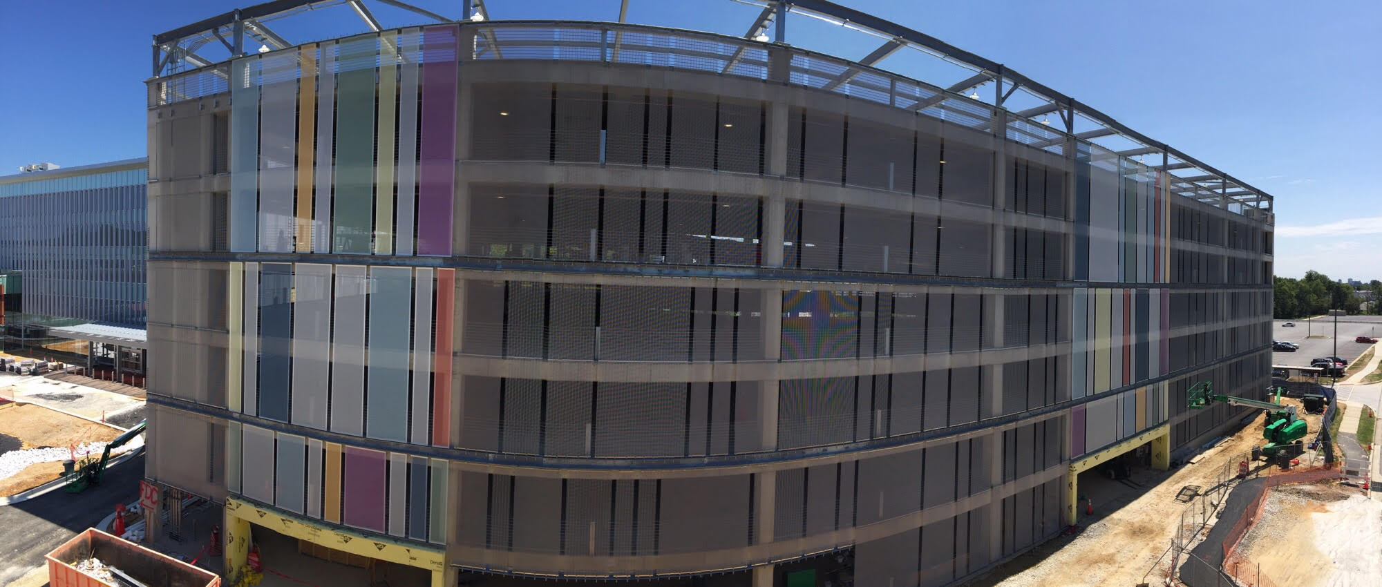 A wide shot of a colorful slotted facade sat on two small parts of a parking structure.