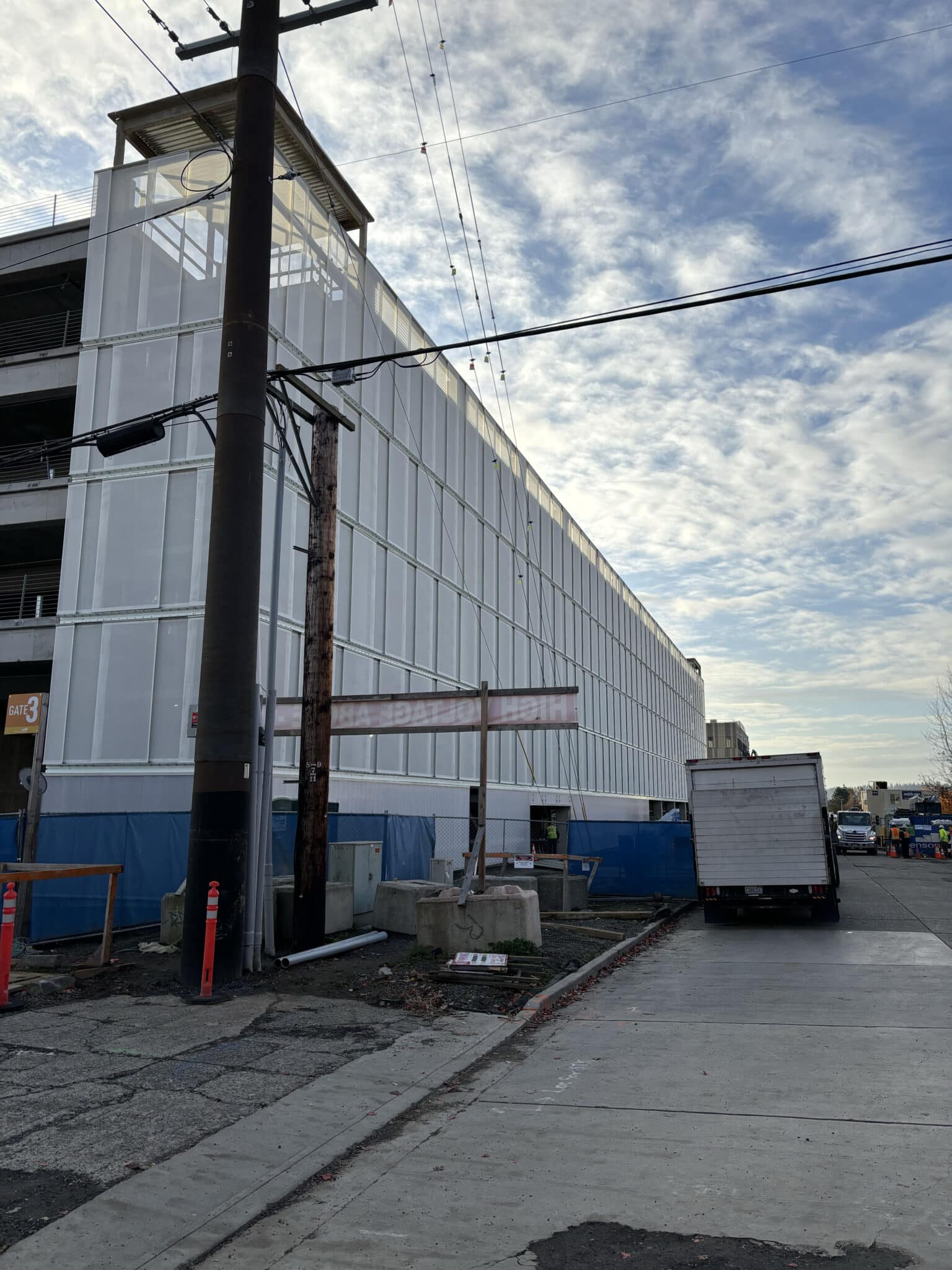 A white, two tiered slotted facade sat on a parking structure.