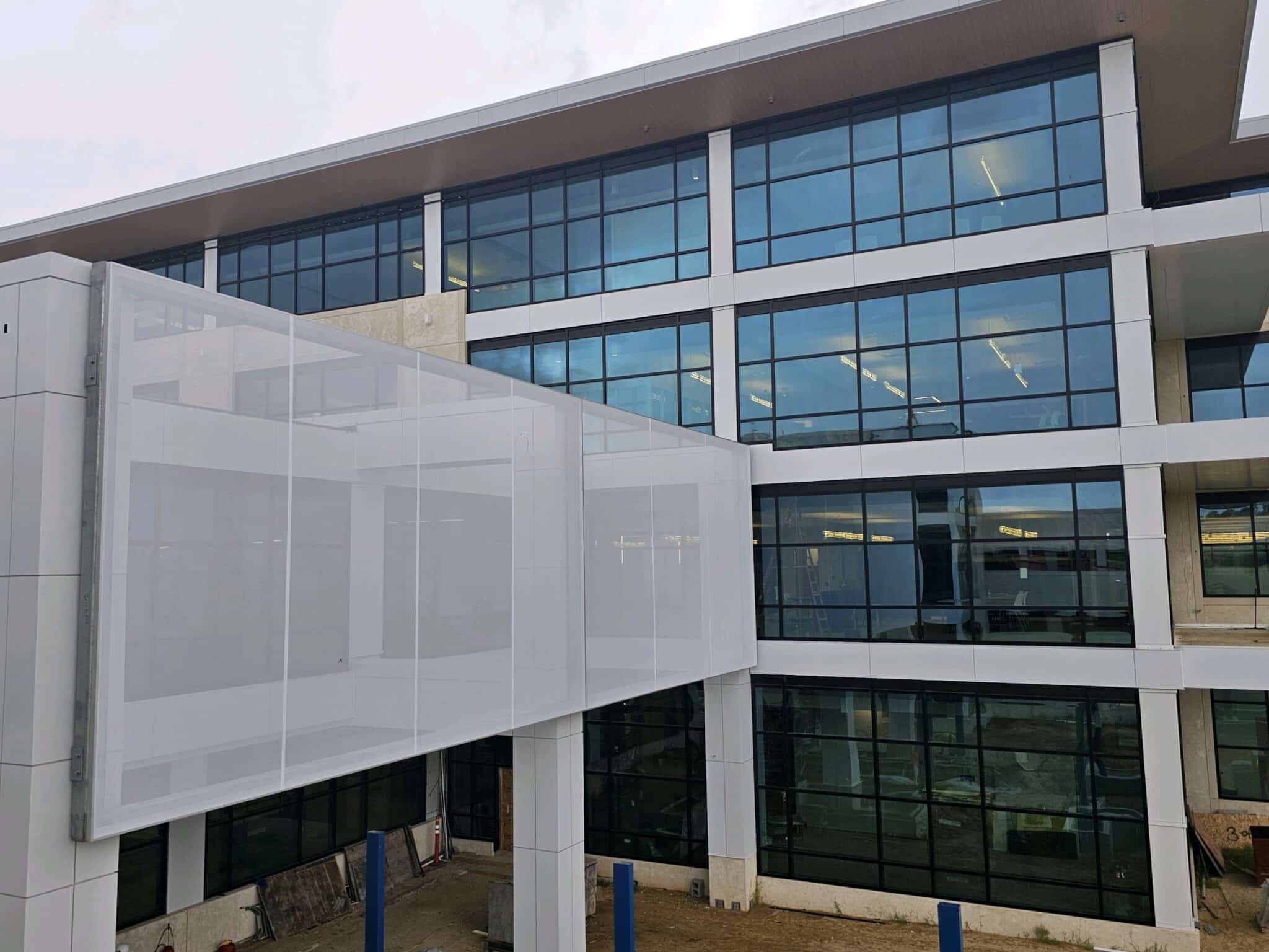 A simple white facade suspended above the entrance of a building.