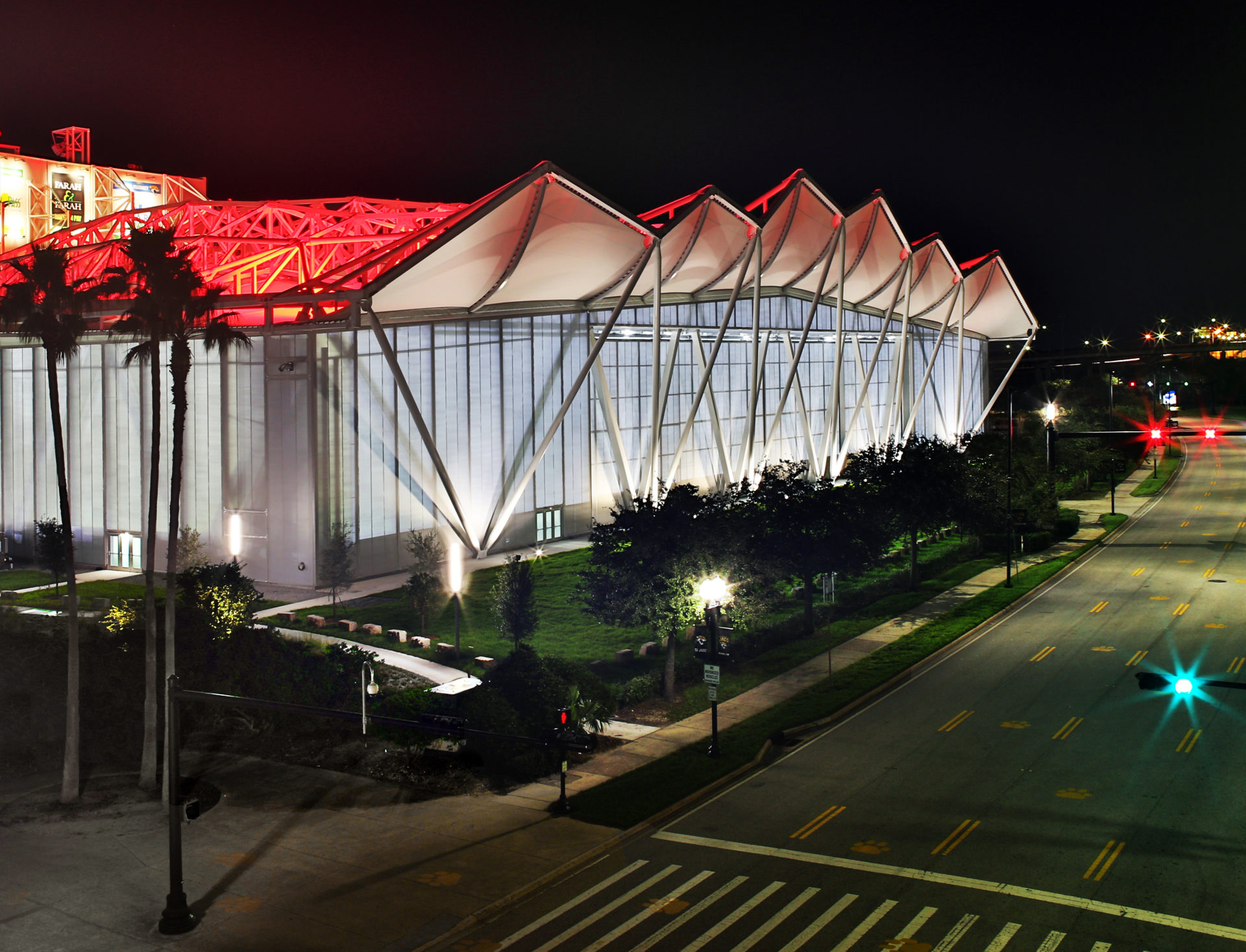 A view of the roof facade at night lit up with red.