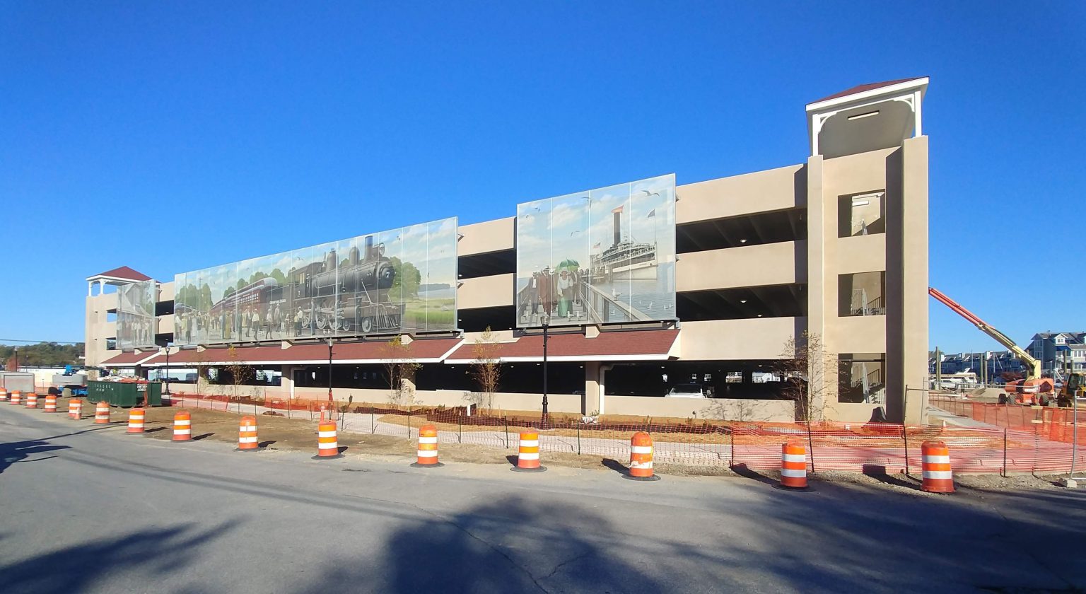A graphic facade on a parking garage that features imagery of a train.