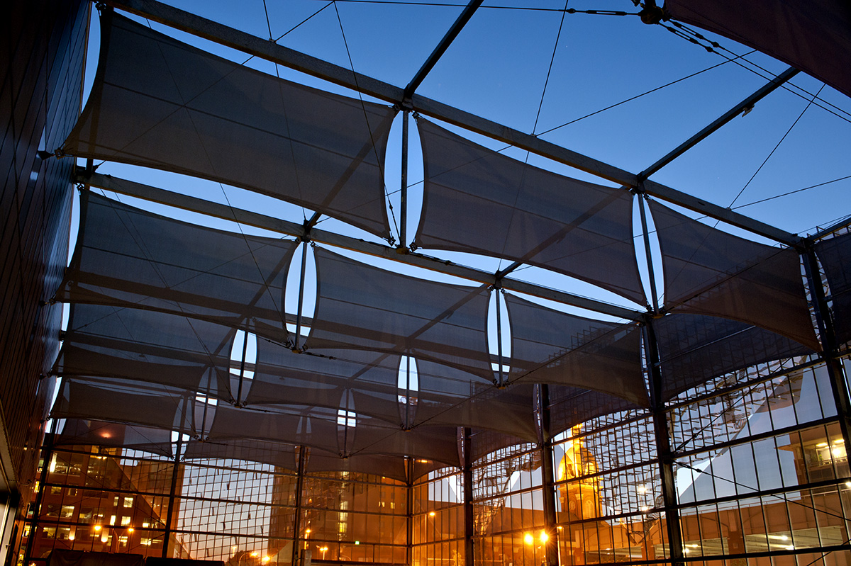 A view of the facade panels at night lit up from the dock lights.