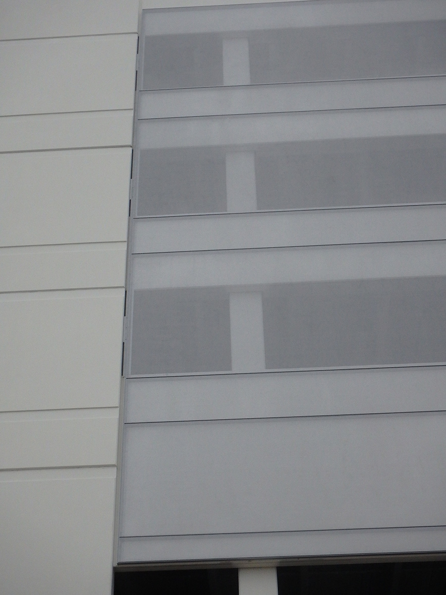 A sidewalk view of the facade showing the interior structure, implying the ventilation and breathability of the facade.