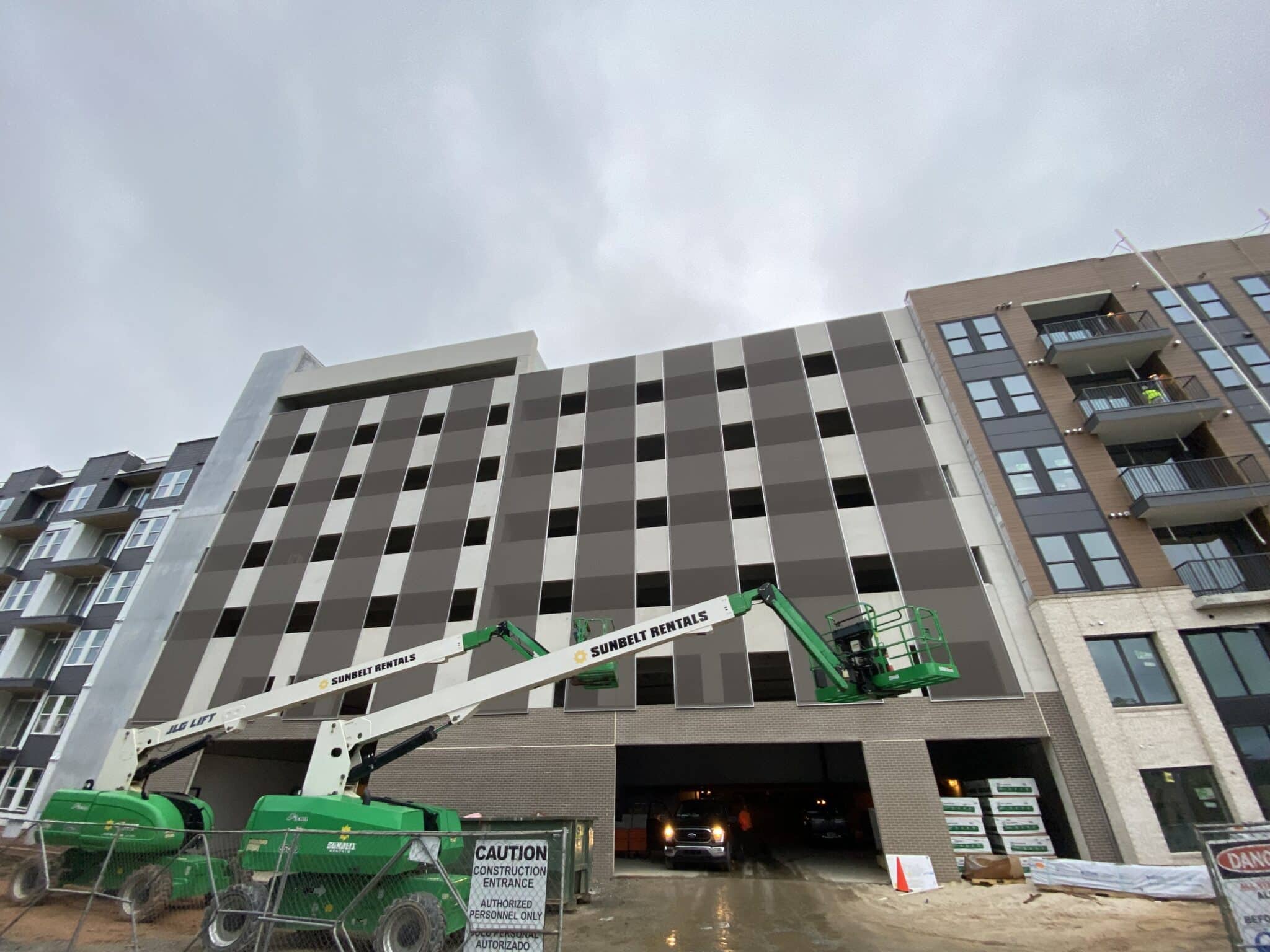Nine brownish grey slotted facades tower six stories.