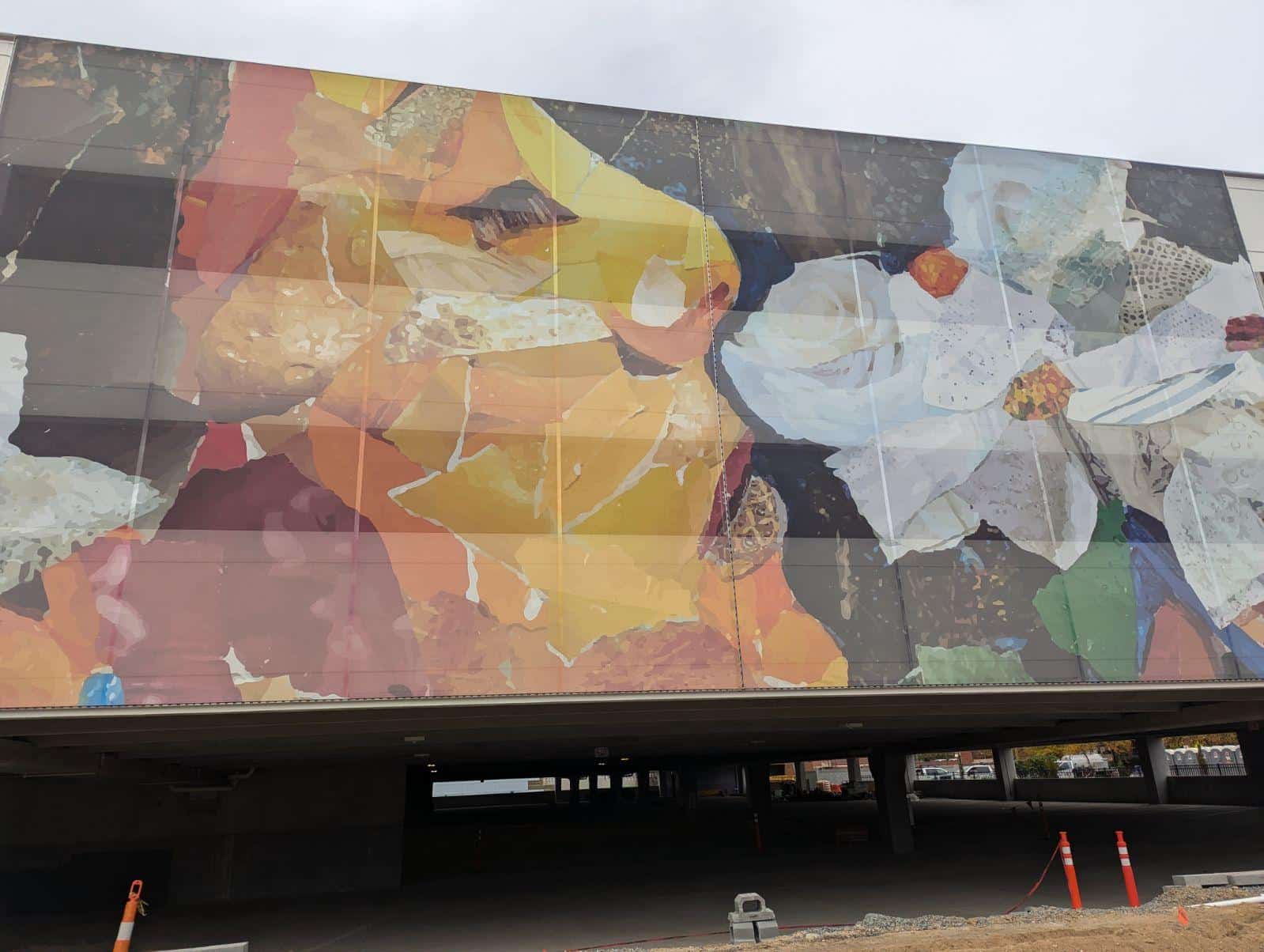 Mosaic imagery of a woman sniffing flowers.