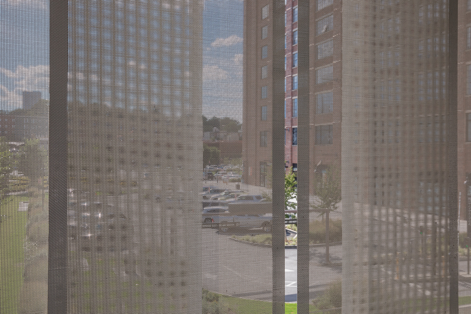 A view from inside of the parking structure looking out through the facade.