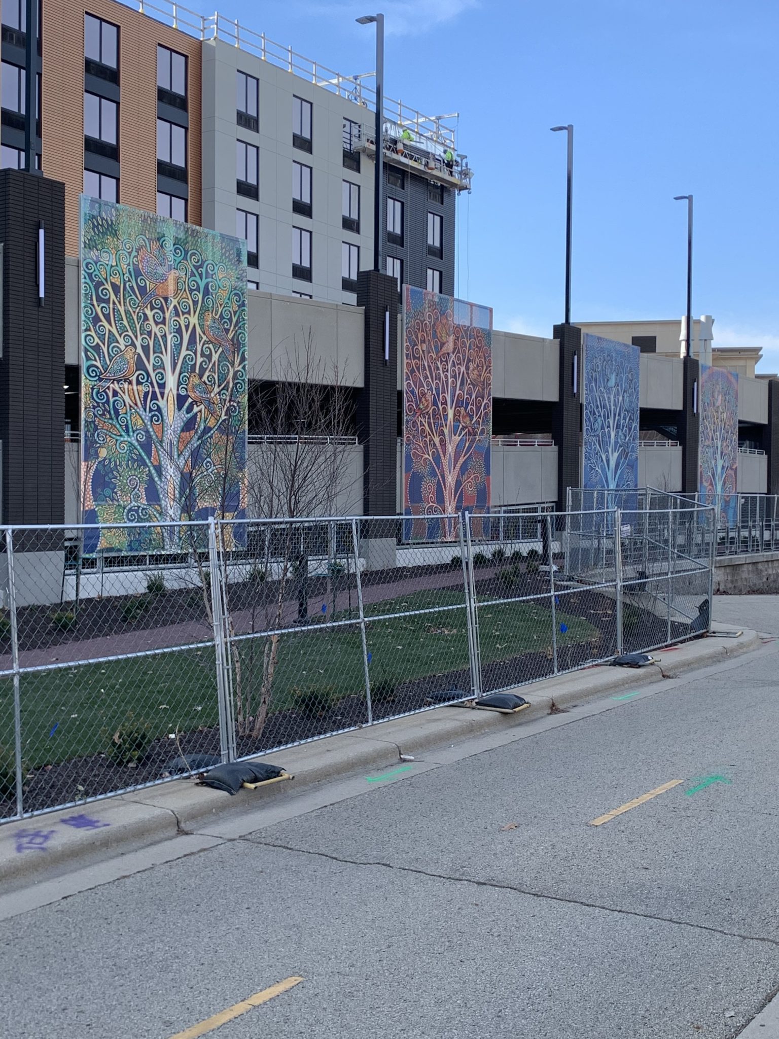 Colorful facade screening with a tree and bird motif.