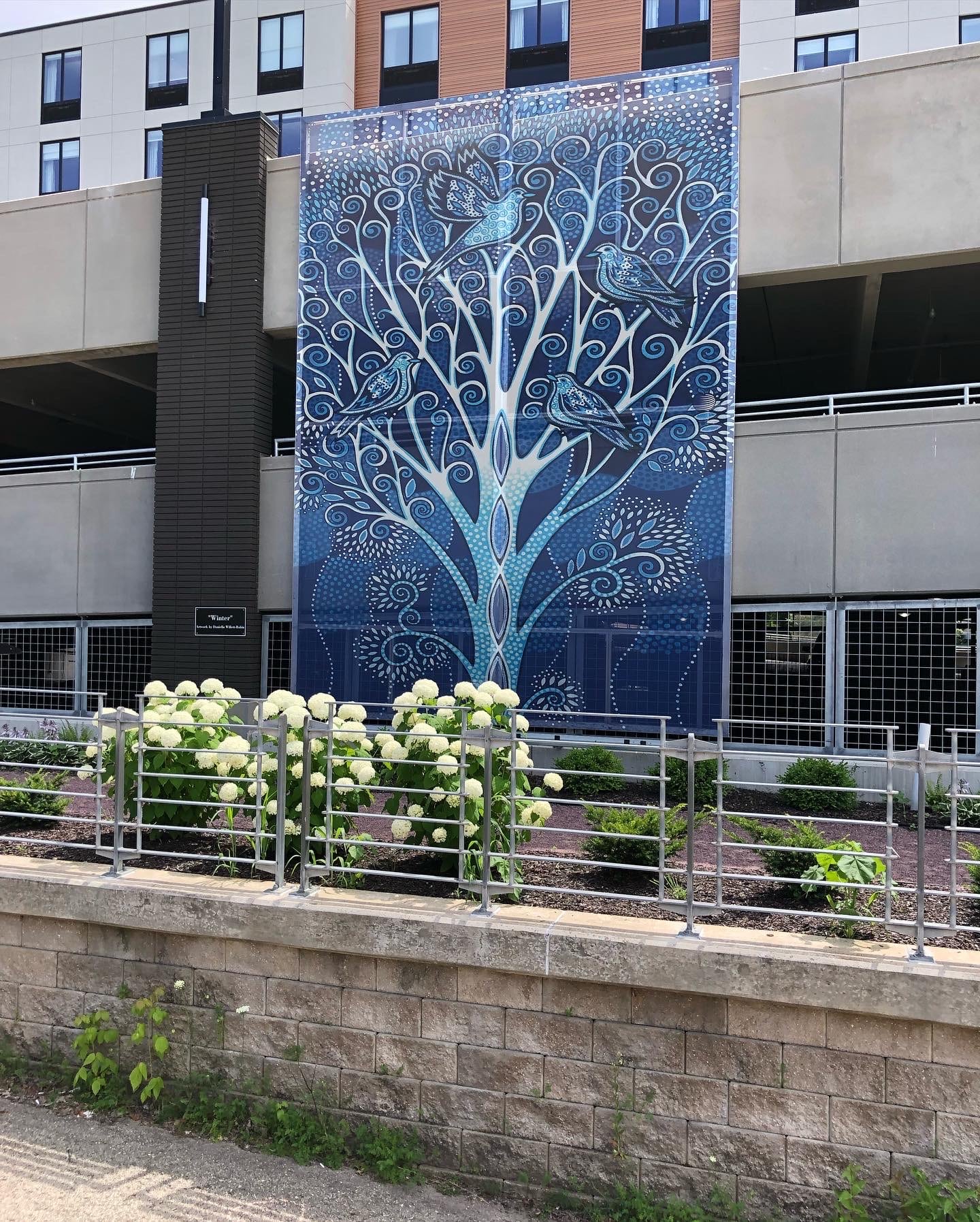 The blue tree motif with the birds sat on the branches.