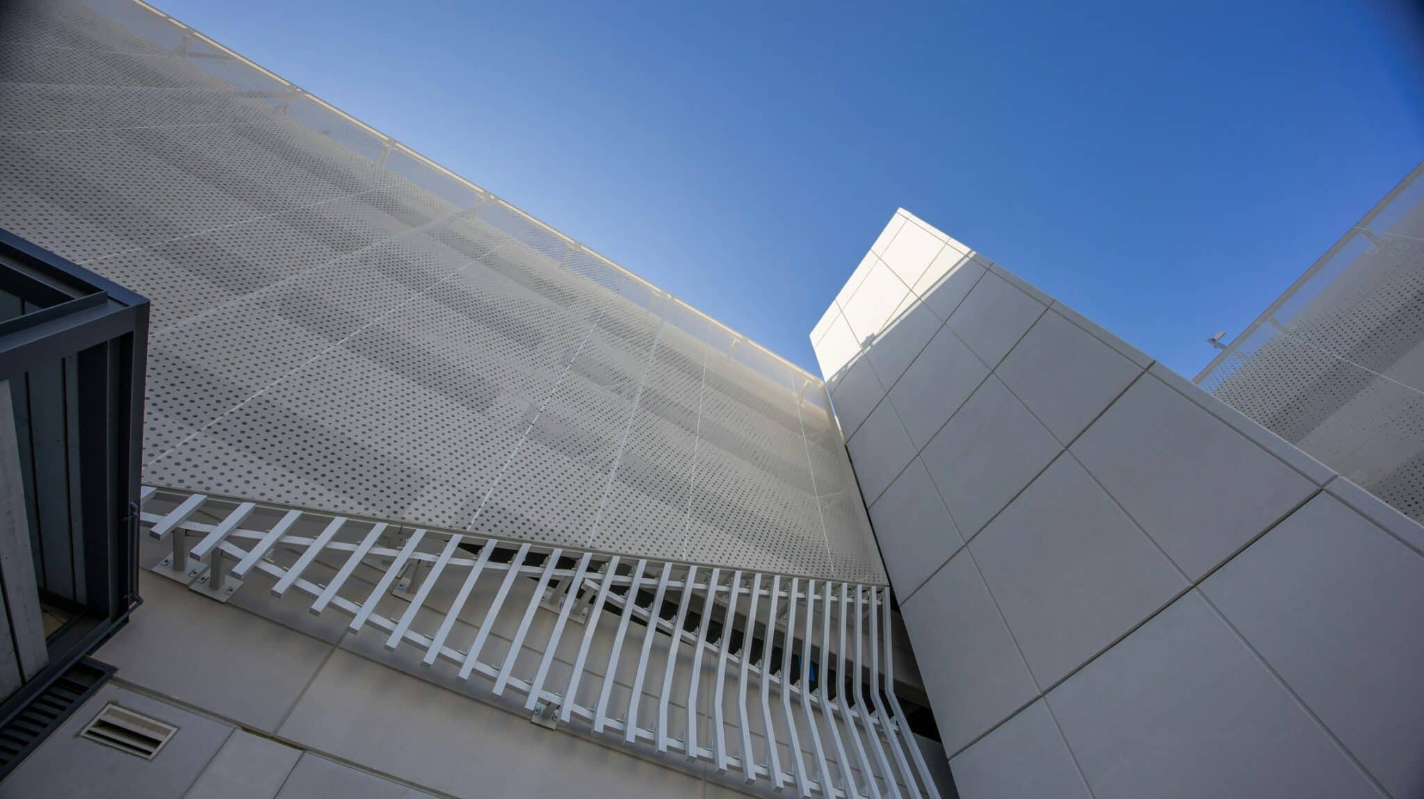 A close up of the two parts of the facade. The slotted portion and the metal sheet with small circles routed into it for airflow.
